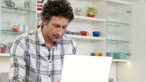 Mature-man-smiling-and-using-laptop