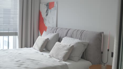 modern bedroom interior design and decoration with white and grey bedding sheet, white chair, night light headboard.