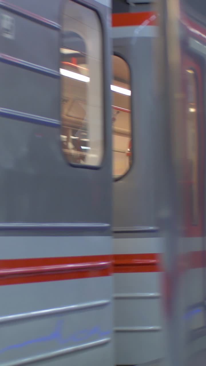 Metrotog ankommer til station, mens passagerer stiger på og af