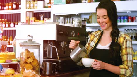 smiling waitress making cup of coffee at counter