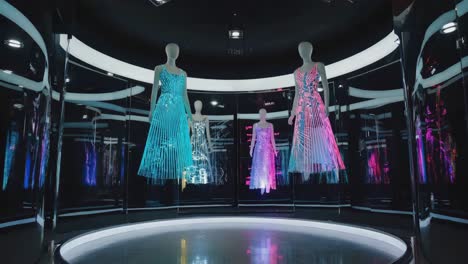 futuristic glowing dresses on mannequins in modern exhibit