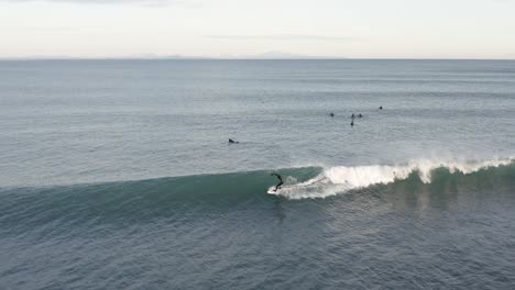 Isländischer-Wintersurfer-Trifft-Auf-Sanfte-Welle-Im-Kalten-Atlantikwasser,-Aus-Der-Luft