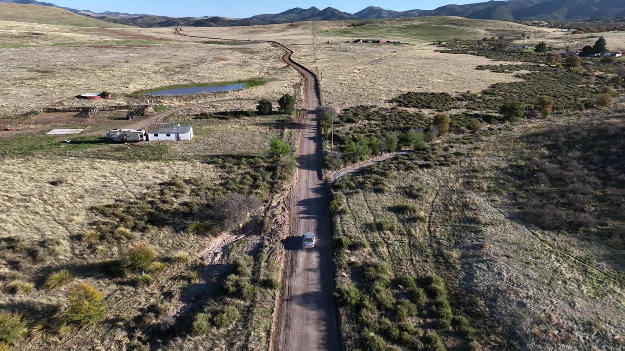 fotografía de un avión no tripulado de un coche conduciendo por un camino de tierra en willcox, arizona, después de un disparo aéreo