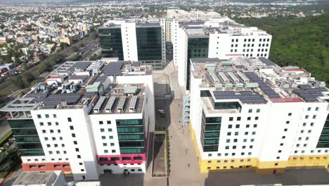 Aerial-Drone-Shot-Of-Buildings-With-Solar-Panels-Near-Highway