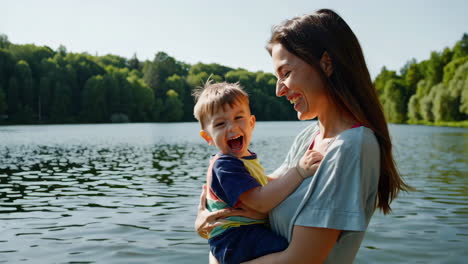 joyful mother and child laughing by the lake