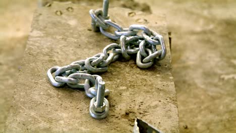 large industrial chain secured into. block of concrete with video moving around.