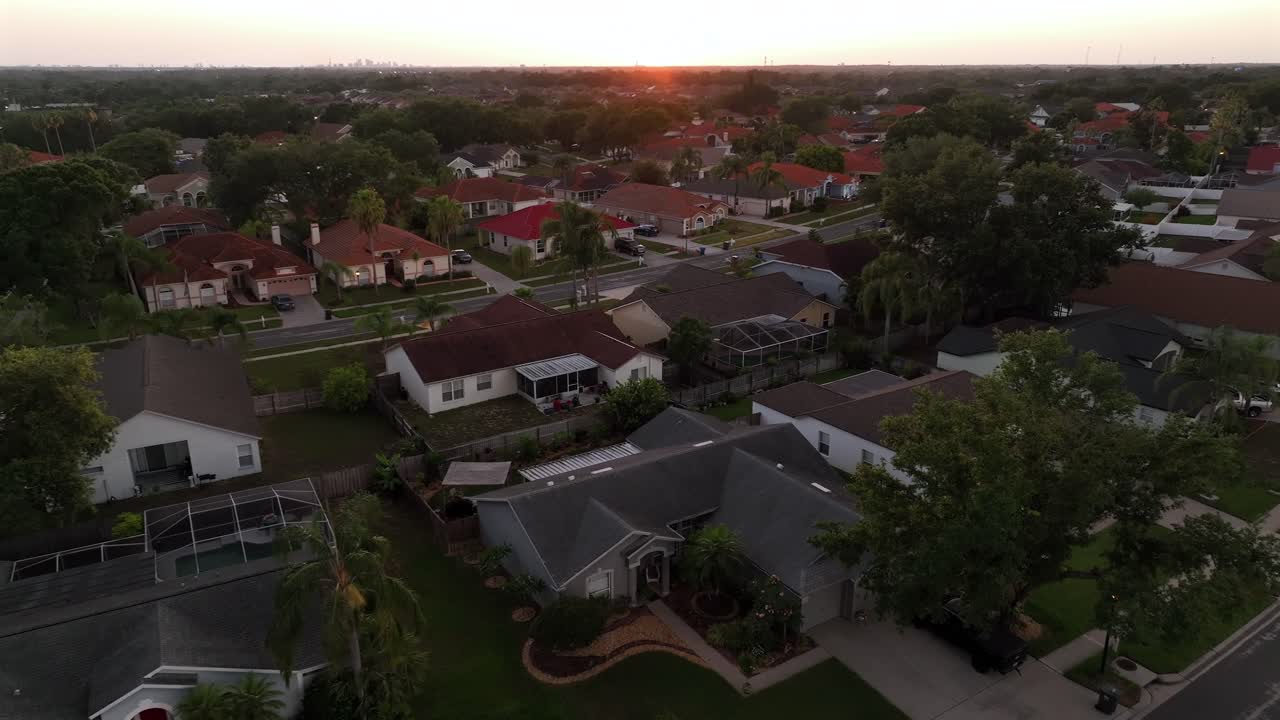 Aerial establishing shot of luxury neighborhood with mansion and villas during golden sunset. Quiet suburb housing area in Florida, USA. Wide shot.