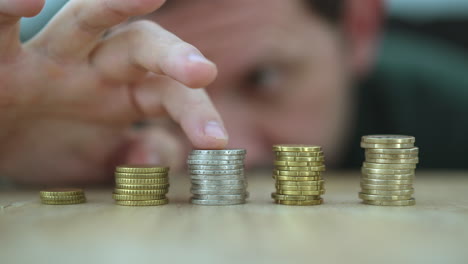 Close-up-shot-of-man-counting-stack-of-euro-coins-on-table,-in-focus