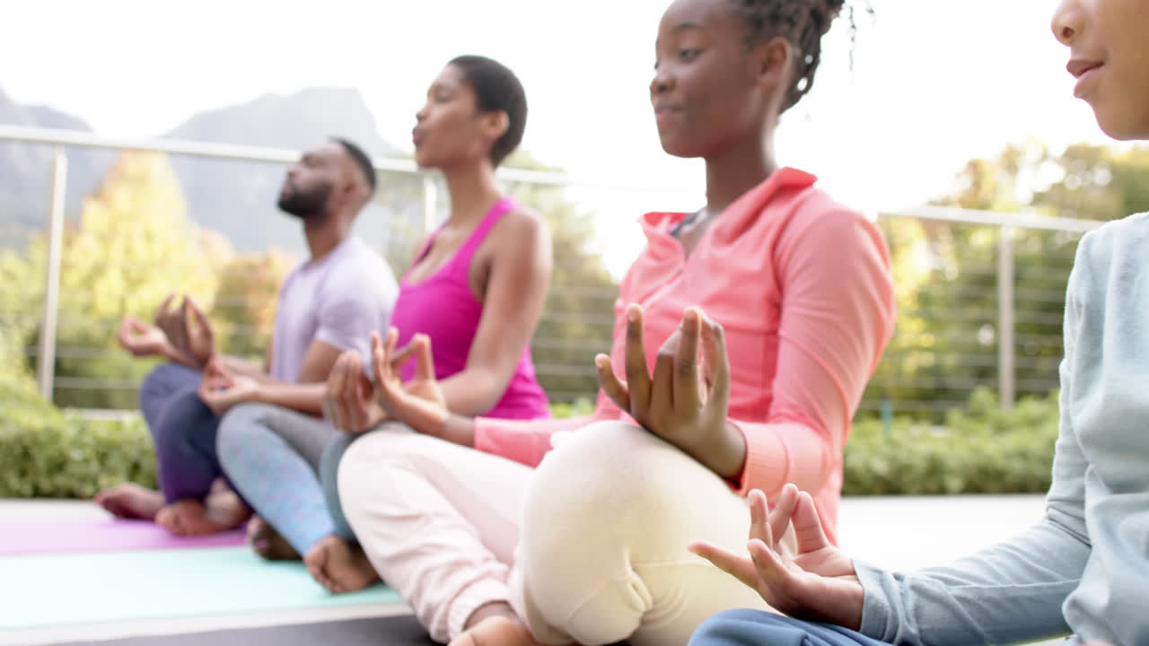 felices padres afroamericanos, hijo e hija practicando yoga en un jardín soleado, en cámara lenta.