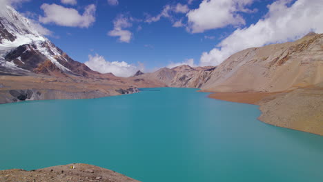 tomada de avión no tripulado del lago tilicho en el circuito de montaña de annapurna, el lago de mayor altitud del mundo bajo un cielo azul con nubes, montañas, naturaleza feliz, clima frío nepal 4k