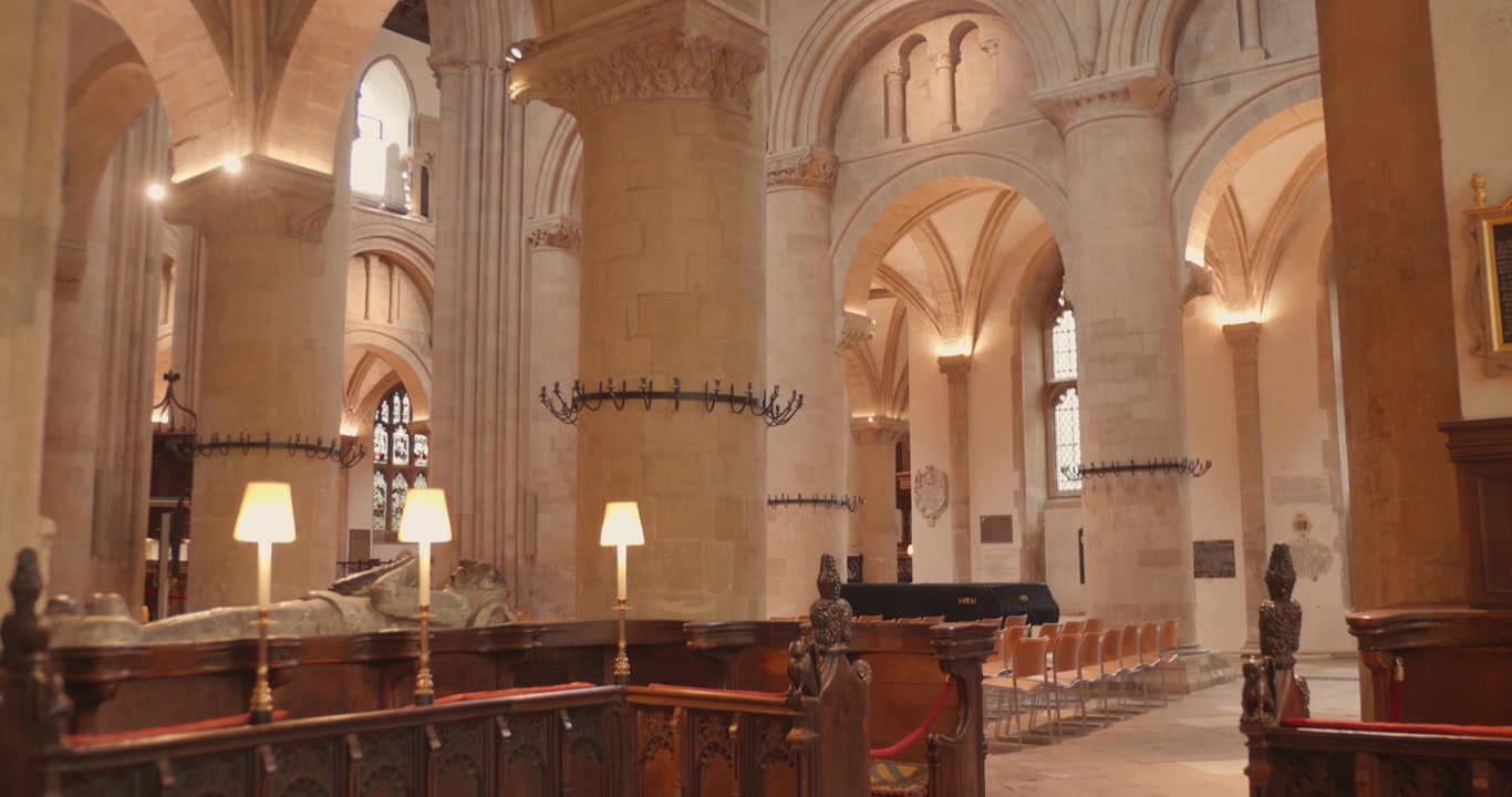 Warm light fills stone arches and columns inside historic cathedral nave in Oxford