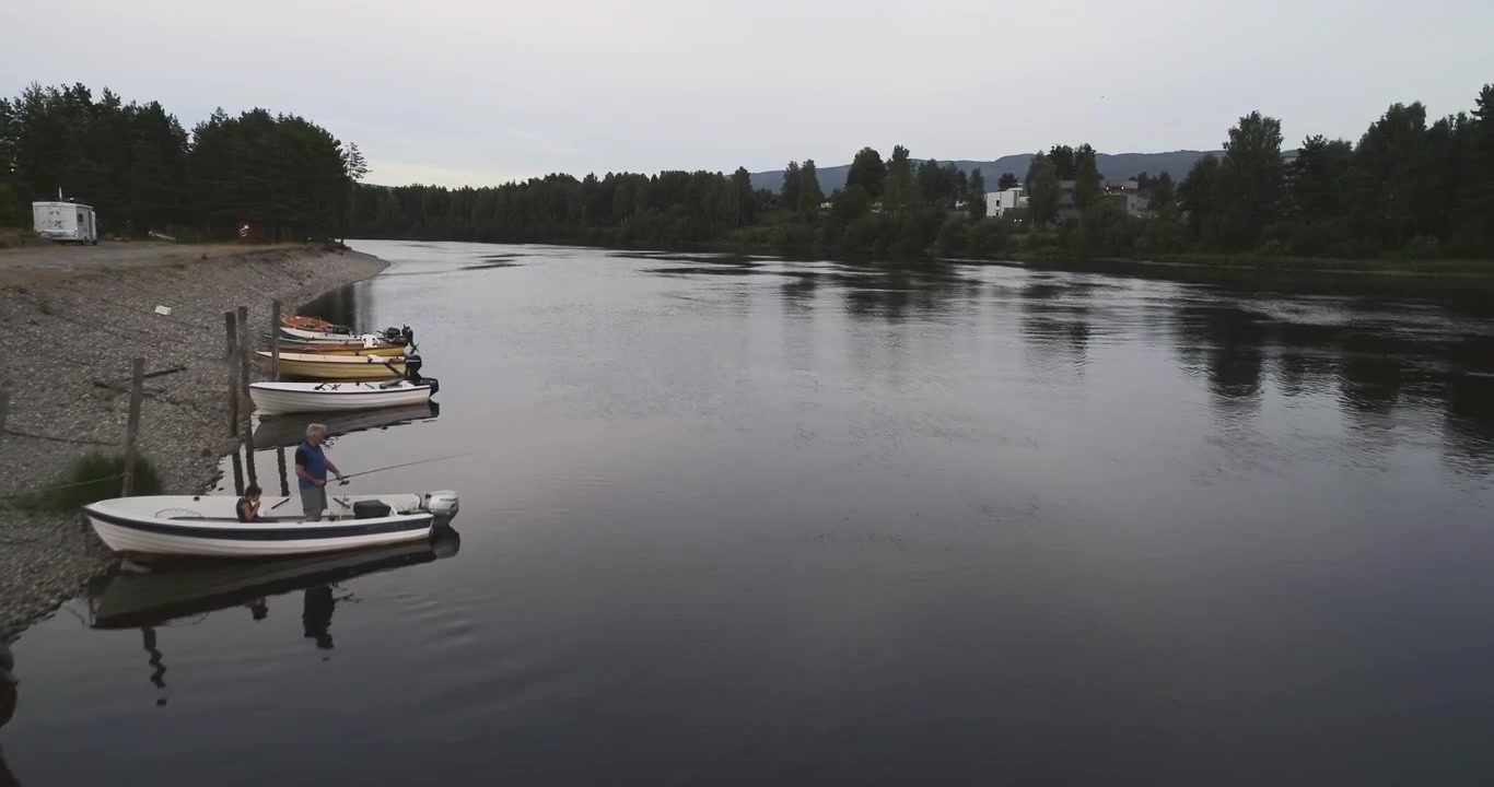 Vista aerea di nipote e nonno che pescano su una piccola barca lungo un fiume in Norvegia