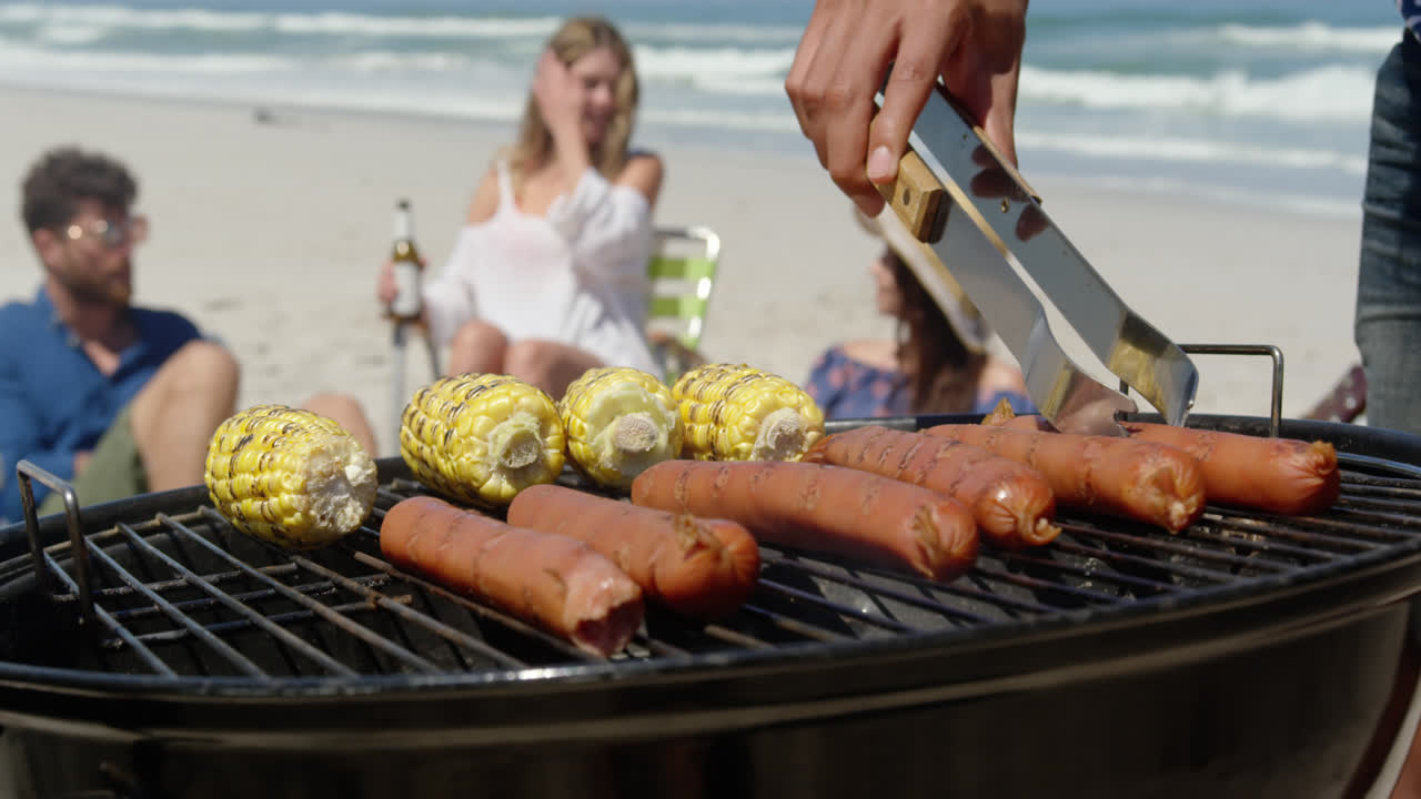 hombre cocinando comida en la barbacoa en la playa 4k