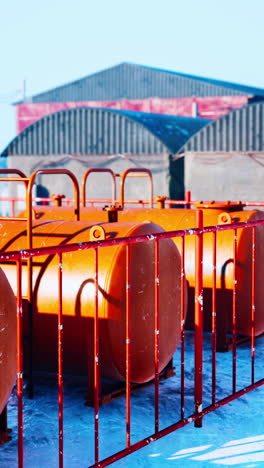 orange tanks with red fence in snowy environment