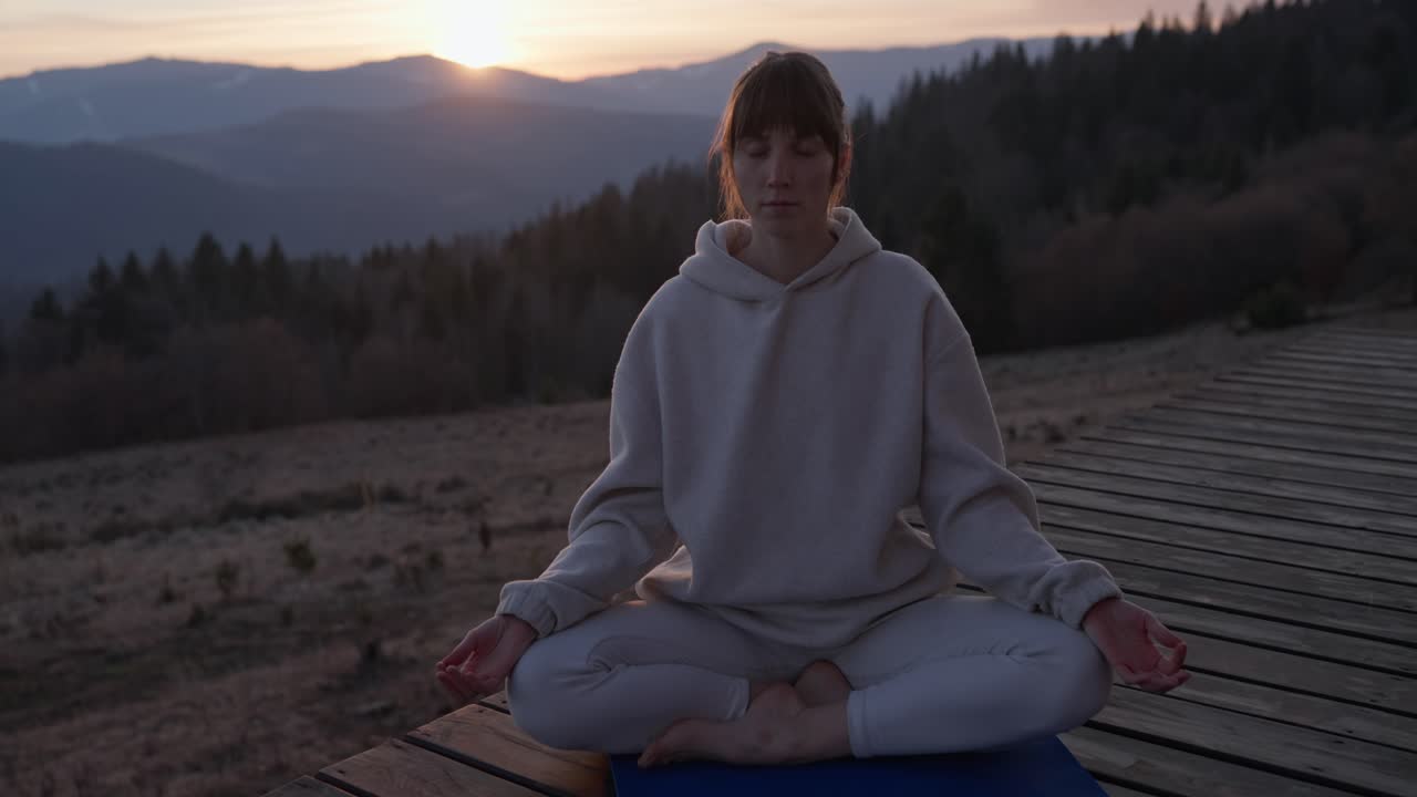 mujer meditando en las montañas al atardecer