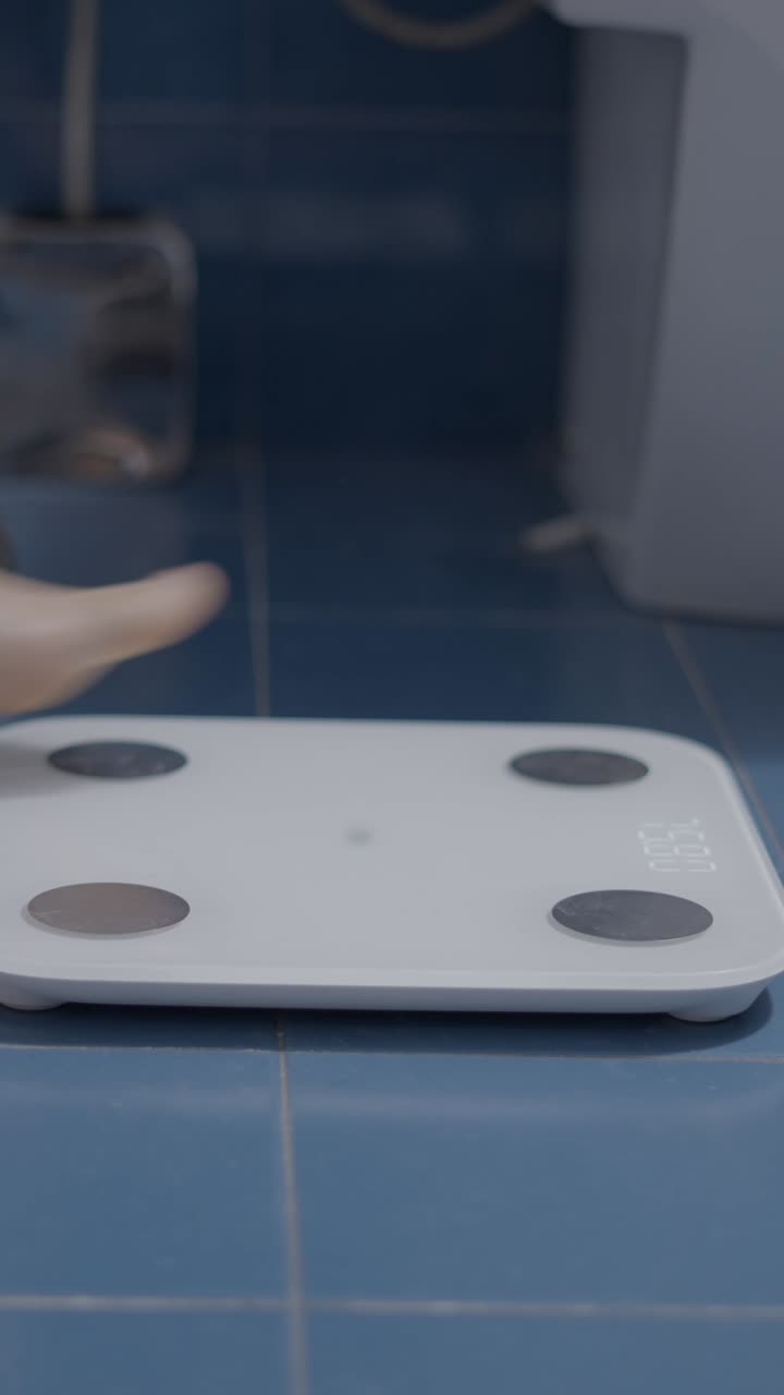 Person weighing themselves on a digital bathroom scale