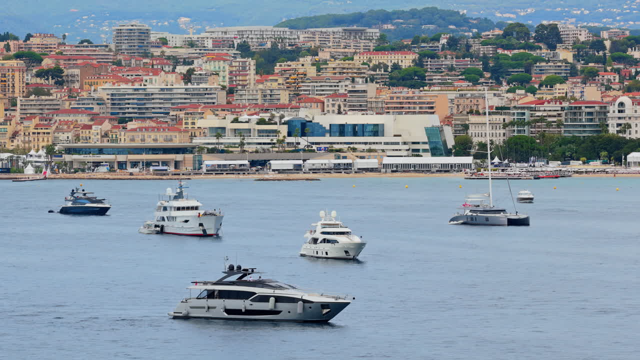 Vista aerea da drone di yacht di lusso ancorati al largo con il Palais des Festivals e lo skyline della città di Cannes sullo sfondo