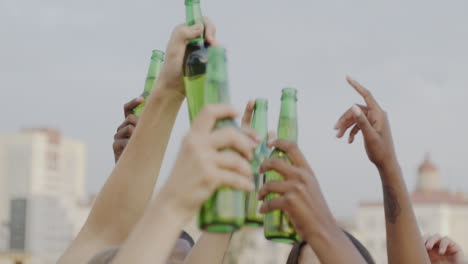 friends celebrating with beer on rooftop
