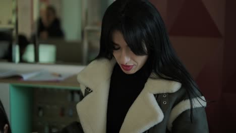 professional female manager in a black formal outfit, walking through the office, interacting with colleagues, holding documents and a laptop, showcasing leadership and professionalism