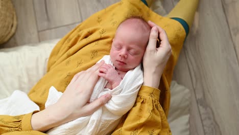 cute baby sleeping in hands of loving mother