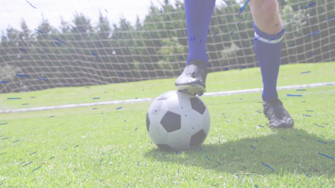 Mandlig fodboldspiller placerer foden på bolden, skubber og guider bolden til sportskontroltræning ved målet.