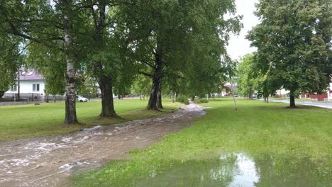 flooded river running through a park in slovak village, pan shot