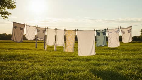 a warm evening with laundry drying in the gentle breeze, capturing the essence of outdoor chores and the serenity of nature under the soft glow of the setting sun