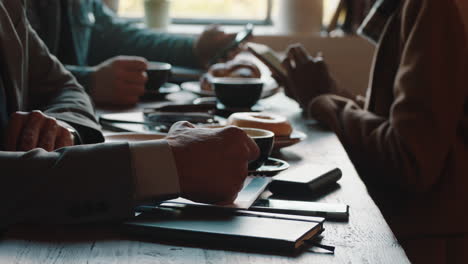 close-up-businessman-signing-contract-deal-for-business-partnership-writing-signature-on-document-meeting-in-busy-cafe