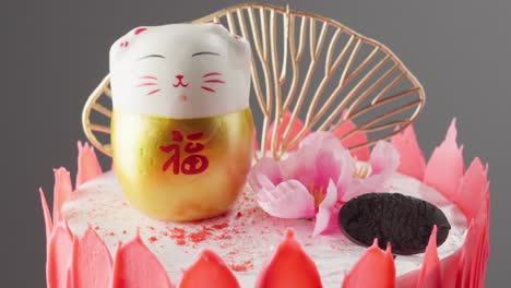 Slowly-panning-shot-of-a-Chinese-cat-on-top-of-a-cake