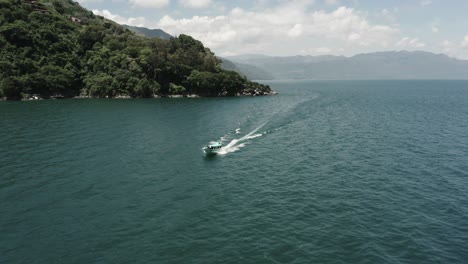 Lancha-Navegando-En-El-Lago-De-Atitlán,-Guatemala.-Reversa-Aérea