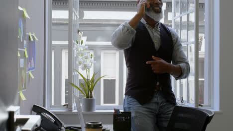 hombre de negocios hablando por teléfono móvil cerca de la ventana 4k
