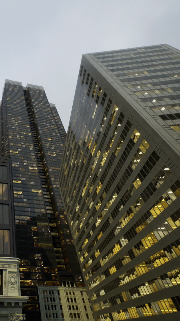 Edifici cittadini che riflettono le luci durante le ore serali in un contesto urbano.