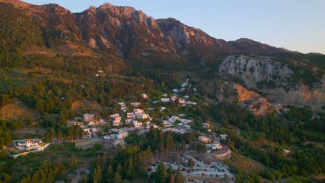 vista aérea acercándose a la aldea de zia en la ladera de la montaña durante la puesta de sol