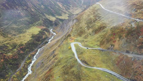 Vista-Aérea-Paso-Furka-Camino-Sinuoso-Y-Un-Río-En-Suiza,-Hermosa-Naturaleza-Suiza,-Otoño