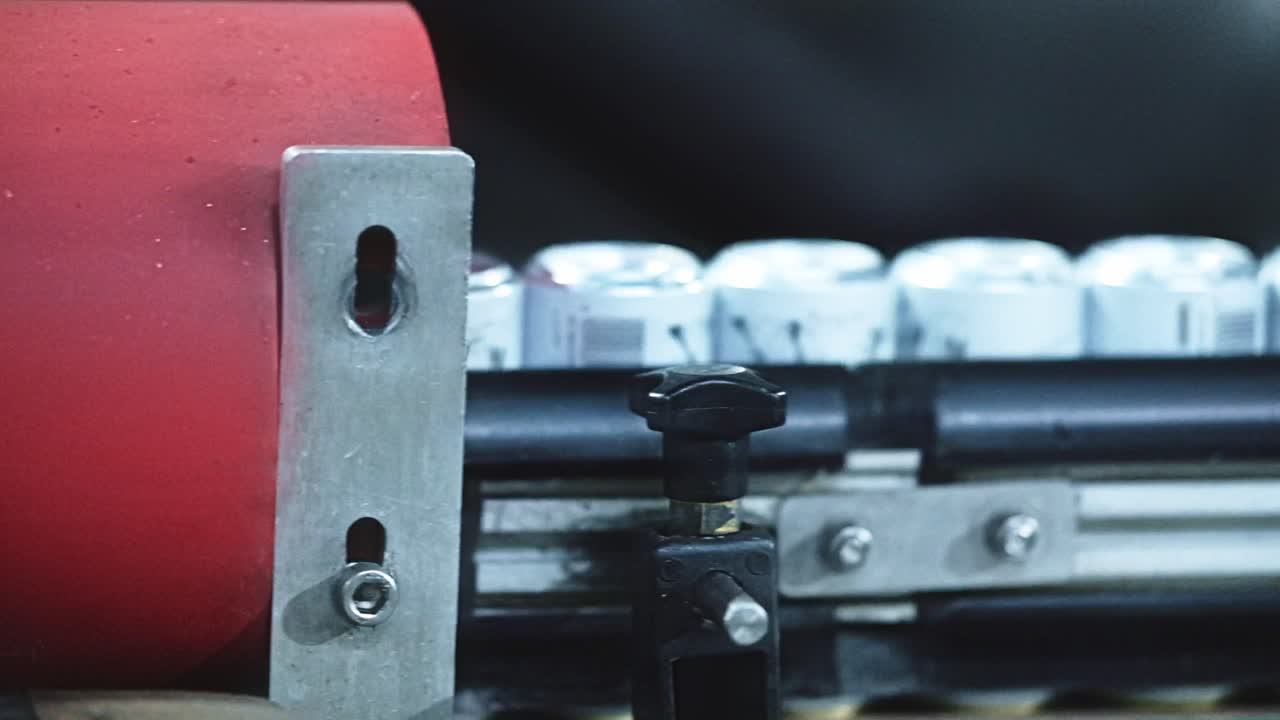 Beverage cans moving through a machine that flips the cans