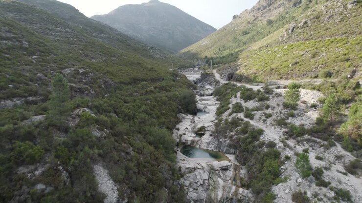 Drone flying above the sete Lagos trekking hiking route path in Portugal national park peneda geres, aerial view of the valley