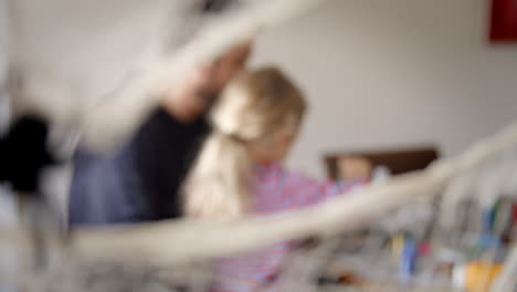 Father-And-Daughter-Making-Halloween-Masks-At-Home-Together