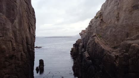 imágenes de drones volando entre dos pequeños acantilados sobre el océano en donegal, irlanda