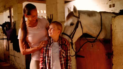 madre e hija de pie con el caballo 4k