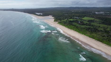 Paisaje-Tranquilo-De-La-Playa-De-Pertenencia-En-Byron-Bay,-Nsw,-Australia---Disparo-Aéreo-De-Drones