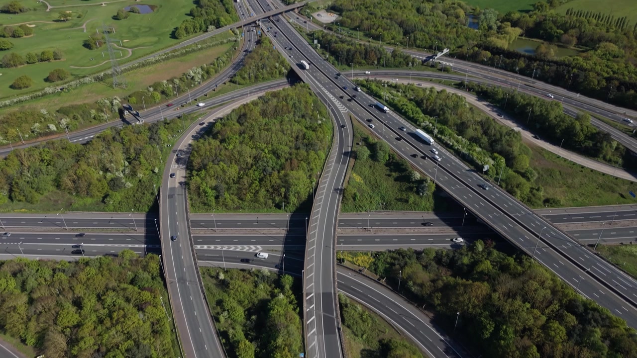 Vehicles Navigating Complex Highway Interchange in Lush Green Landscape