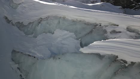 panorámica: glaciar derritiéndose bajo el sol en una montaña de los alpes suizos en invierno