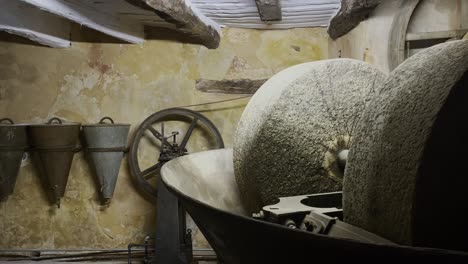 workshop with large stone wheel and old equipment for pressing olive oil in france