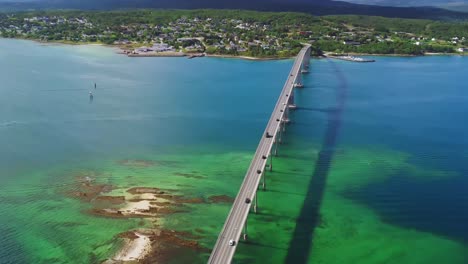 vista aérea del puente y el tráfico sobre el fiordo noruego, cruce de gisundbrua que conecta la isla de senja y la ciudad de finnsnes, disparo de drones