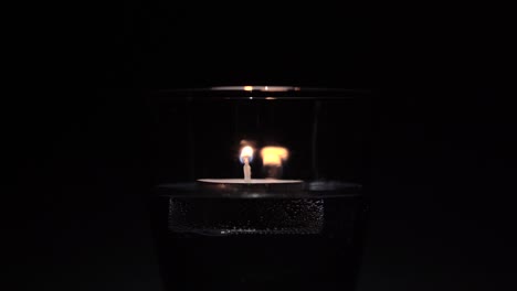 lampion ardiente en un vaso de superficie de agua