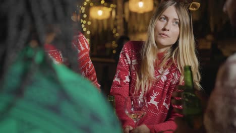 close up shot of a group of friends celebrating christmas at a bar