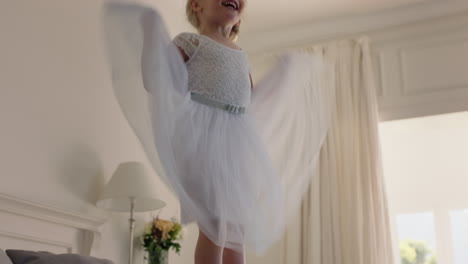 beautiful little girl jumping on bed having fun child in playful mood enjoying weekend morning at home