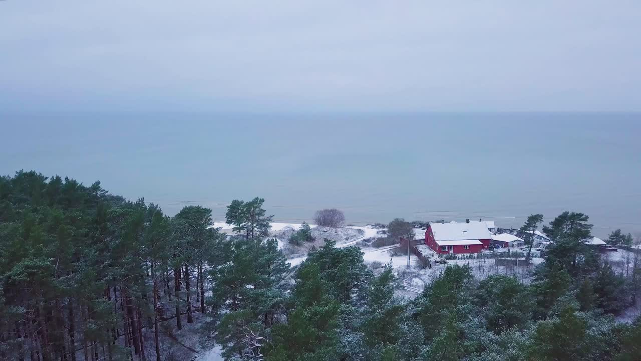 흐린 겨울날 발트해 연안의 아름다운 공중 전망, 눈으로 덮인 백사장이 있는 해변, 해안 침식, 기후 변화, 광각 드론 샷