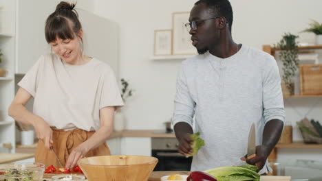 diverse family couple cooking vegetable salad at home