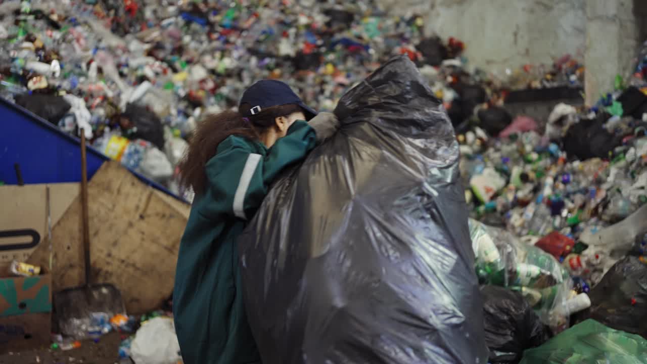mujer afroamericana clasificando bolsas de basura en una planta de reciclaje. control de la contaminación